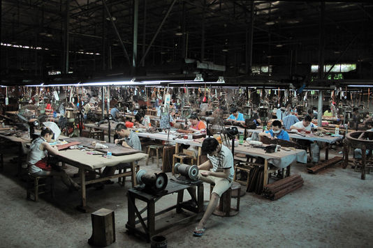 Des ouvriers sculptent des panneaux de bois de rose dans l'un des ateliers de Sanfu Classical Craft Furniture, le principal fabricant de meubles de Xianyou.